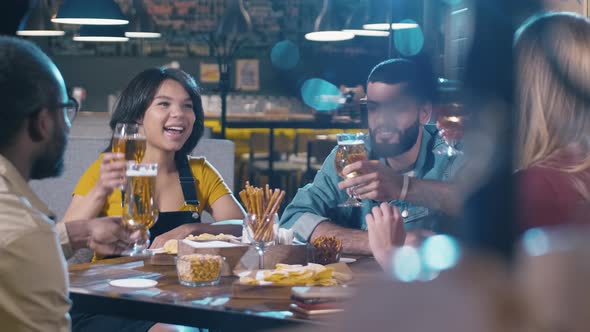 Group of young multiracial friends clinking glasses in bar