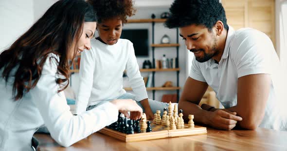 Happy Family Playing Chess Together at Home