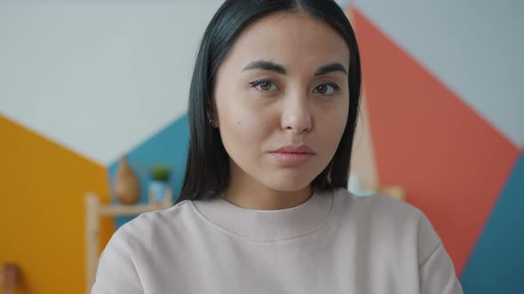 Portrait of Mixed Race Woman Looking at Camera with Serious Face Then Smiling at Home alt