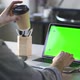 Man Working on Laptop with Green Screen at Office. He Drinks Coffee From Paper Cup. Chroma Key Spbd - VideoHive Item for Sale