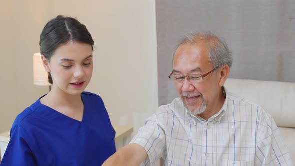 Asian young Caregiver Therapist serve physical therapy for older patient exercise with dumbbell. alt