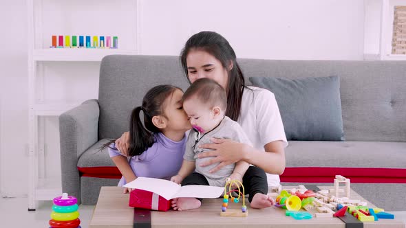 cute daughter sends love mom gift to mother and kiss while play with baby, Mother day concept alt