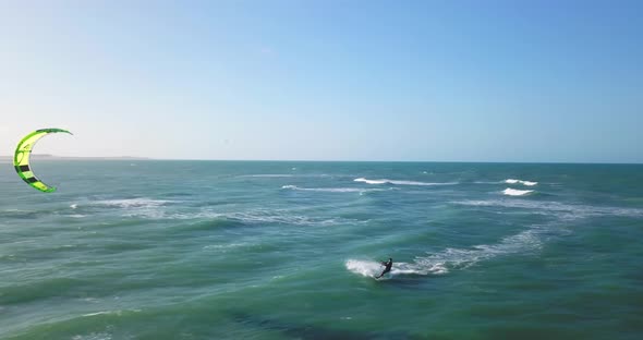 Aerial drone view of a man kiteboarding on a kite board alt