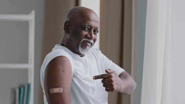 Happy Elderly African American Man Show Adhesive Bandage on Shoulder After Vaccination Smiling alt