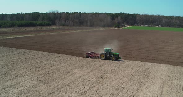 Tractor Cultivating Field at Spring Aerial View alt