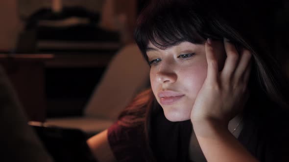 Pretty Caucasian Woman Watching Video On Tablet Laptop In Bedroom At Evening alt