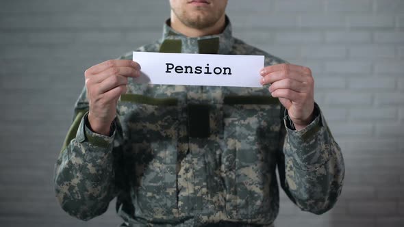 Pension Word Written on Sign in Hands of Male Soldier, Retirement Payments alt