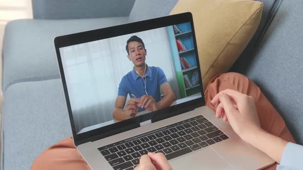 Woman Greeting With Colleagues In Video Conference Call From Laptop At Living Room alt