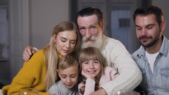 Happy Bearded Man Hugging All His Attractive Joyful Family and Looking at Camera alt