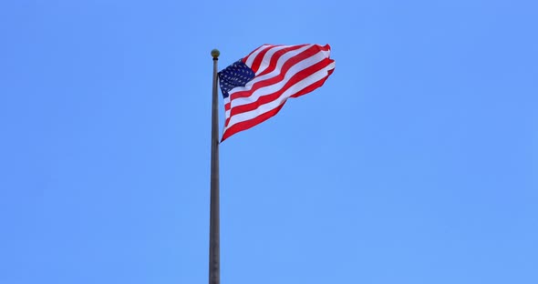 4K American flag - star and stripes floating over a blue sky