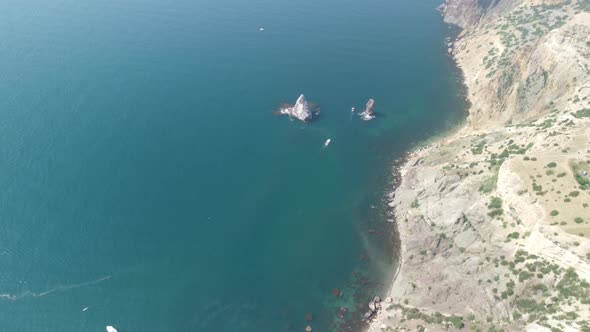 Aerial View From Above on Calm Azure Sea and Volcanic Rocky Shores alt