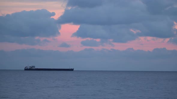 Cargo Ship On the Horizon Evening Sky With Couds