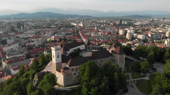 Flying over Ljubljana castle with drone in overseeing the city buildings alt