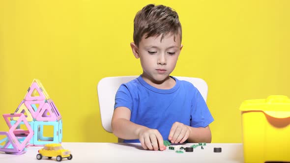 Clever little boy makes crocodile with children's designer. alt
