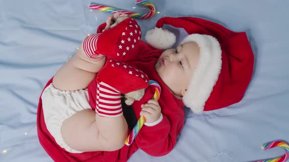 Christmas Portrait of Cute Little Newborn Baby Girl Wearing Santa Hat and Dress Winter Time alt