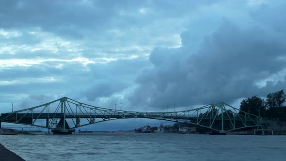 Time lapse of beautiful fasting dark gray rain clouds over the Oskara Kalpaka swing bridge in Liepaj alt