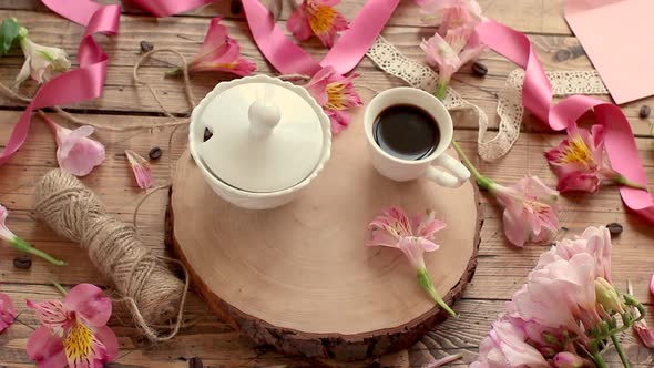 Put a BE MY VALENTINE card near coffee and flowers on a wooden table alt