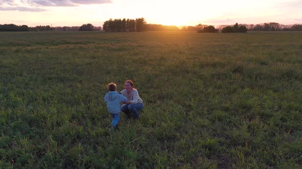 the Child Runs Up To the Mother Holding Hands and Whirling at Sunset alt