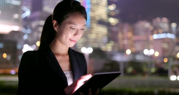 Young businesswoman use of tablet computer at night alt