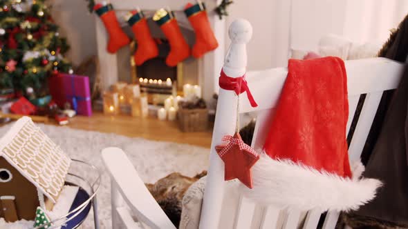 Santa hat and christmas decoration hanging on chair alt