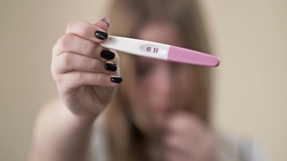 Teenage Girl Shows a Strip Test for Pregnancy