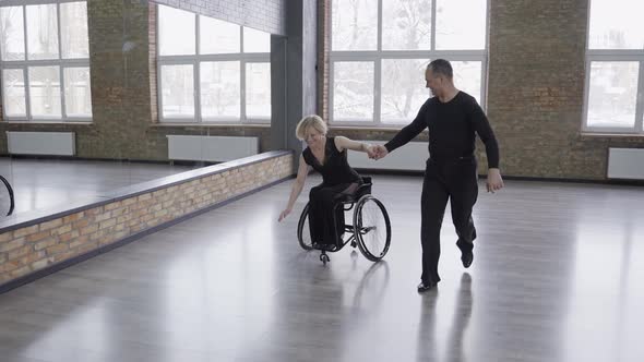 Happy Man Driving and Circling Woman in Wheelchair alt