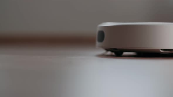 Modern robot vacuum cleaner cleans the floor. Automatic House Cleaning. Housekeeping.