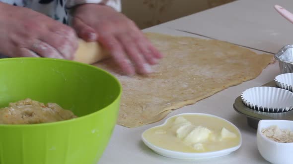 The Woman Rolls Out The Dough. Prepares Cruffin With Raisins And Candied Fruit. alt