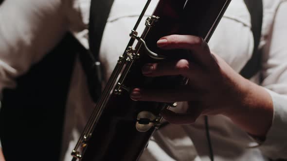 Closeup Fingers of Musician Playing Classical Music on Bassoon in Studio alt