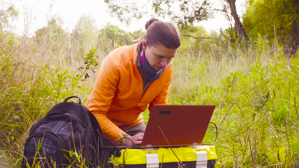 Ecologist working on a laptop in the forest