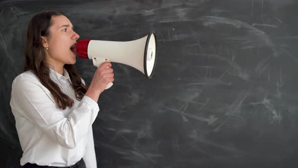 Beautiful Girl Student Stands Near the Chalk Board Holds a Megaphone in Her Hands and Yells alt