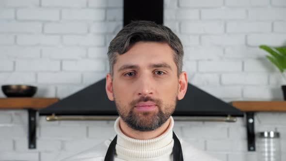 Male online chef standing at kitchen background, distance preparing cook food alt