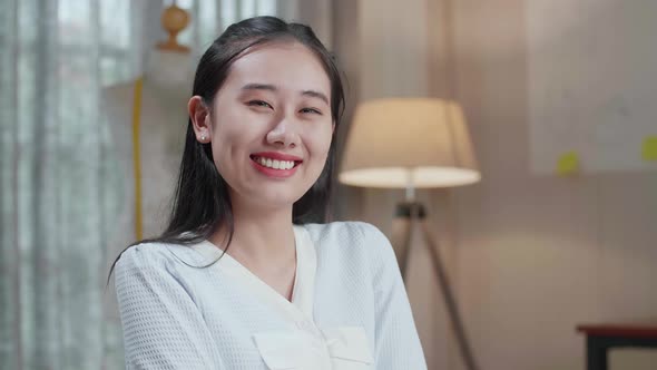 Close Up Of Asian Woman Designer Look At The Layout Bond, Cross Arms, And Smile To Camera alt