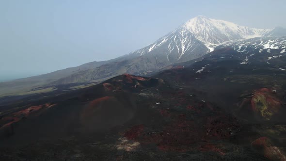 frozen black lava overlooking snow-capped volcanoes