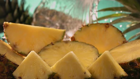 Slow Motion Shot of Pineapple and Water Splashing Through Pineapple Slices alt