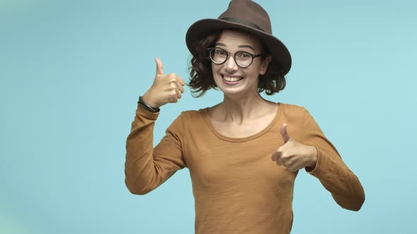Funny and Cute Young Woman Jumping From Bottom with Thumbsup Smiling and Showing Approval Praising