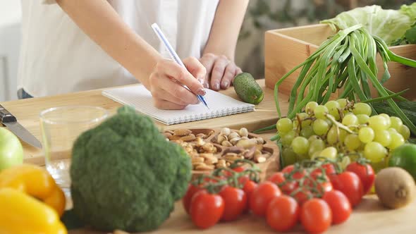 Closeup the Nutritionist Makes Notes in His Notebook About Proper Nutrition There are a Lot of
