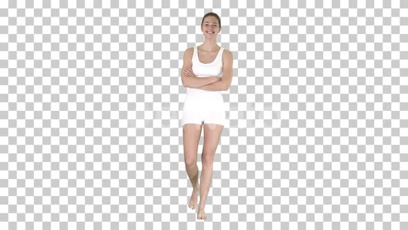 Smiling sports woman walking with arms folded and looking alt