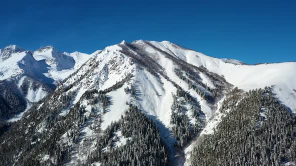 Air Flight Through Mountain Clouds Over Beautiful Snowcapped Peaks of Mountains and Glaciers alt
