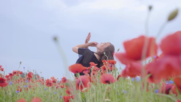 Pretty Girl Dancing in a Poppy Field Smiling Happily. Connection with Nature. Leisure in Nature alt