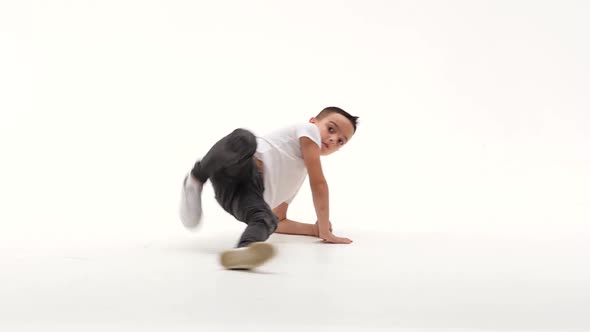 Little Boy Is Dancing a Modern Dance on the White Background in Black Leather Jackets and Jeans alt