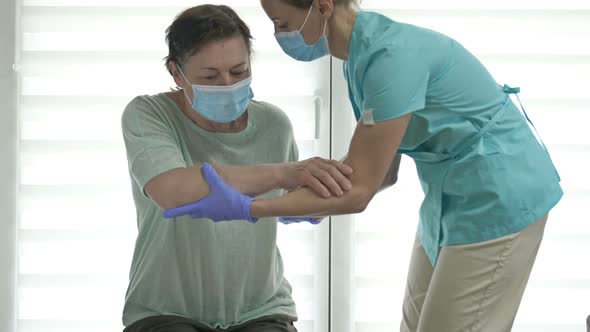 Doctor or Nurse is Helping an Elderly Woman to Get to Her Feet alt