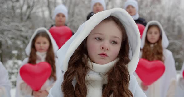 A Group Of Children Sing A Song In A Snowy Park