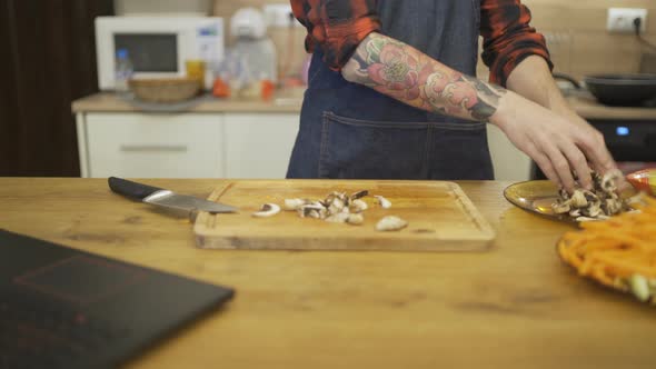 Close Shot of Chef Hands Chopping Mushrooms on a Wooden Chopping Board alt