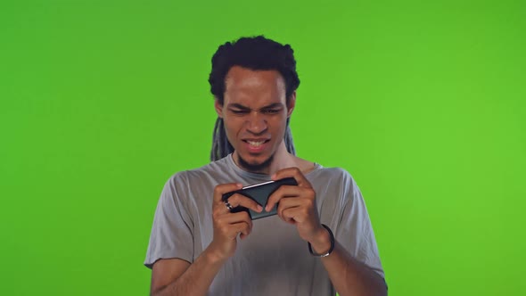 Young African American Man Playing Video Game GSensor Controlling Mobile Phone alt
