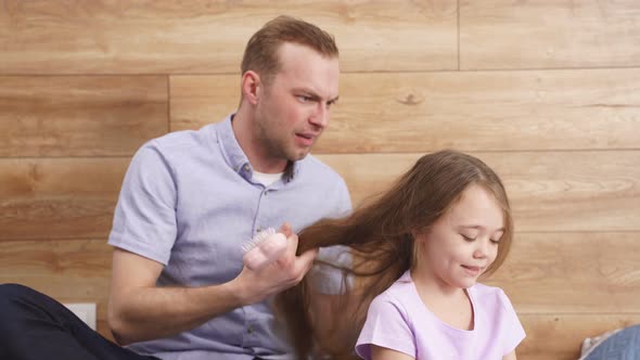 Crazy Father Brushing and Braiding Cute Little Daughter Hair