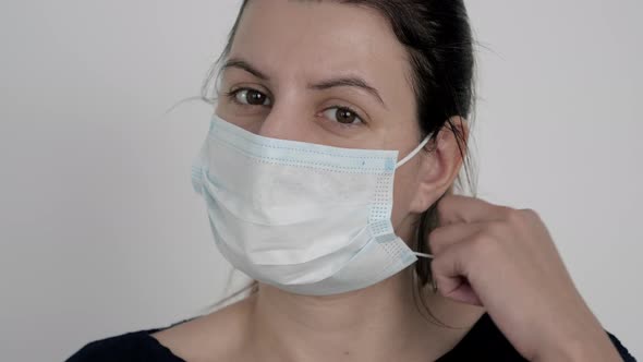 Portrait Woman Take Off Protective Medical Mask From Face And Exhales In Relief