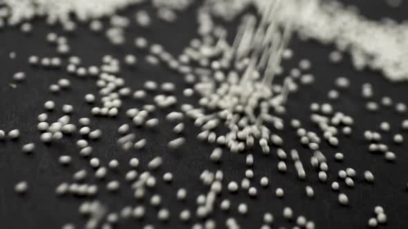 White Granules of Medicine Crumble on a Black Background Close-up Slow Motion alt
