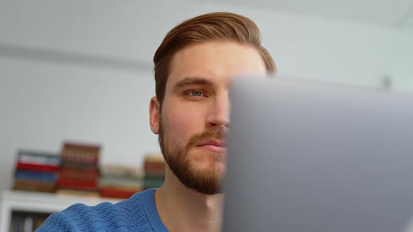 Young male surfing the internet using a laptop alt