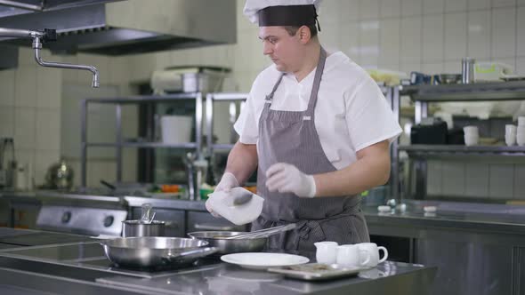 Portrait of Professional Chef in Cook Hat and Apron Adding Sugar in Cooking Pan Turning Pineapple alt